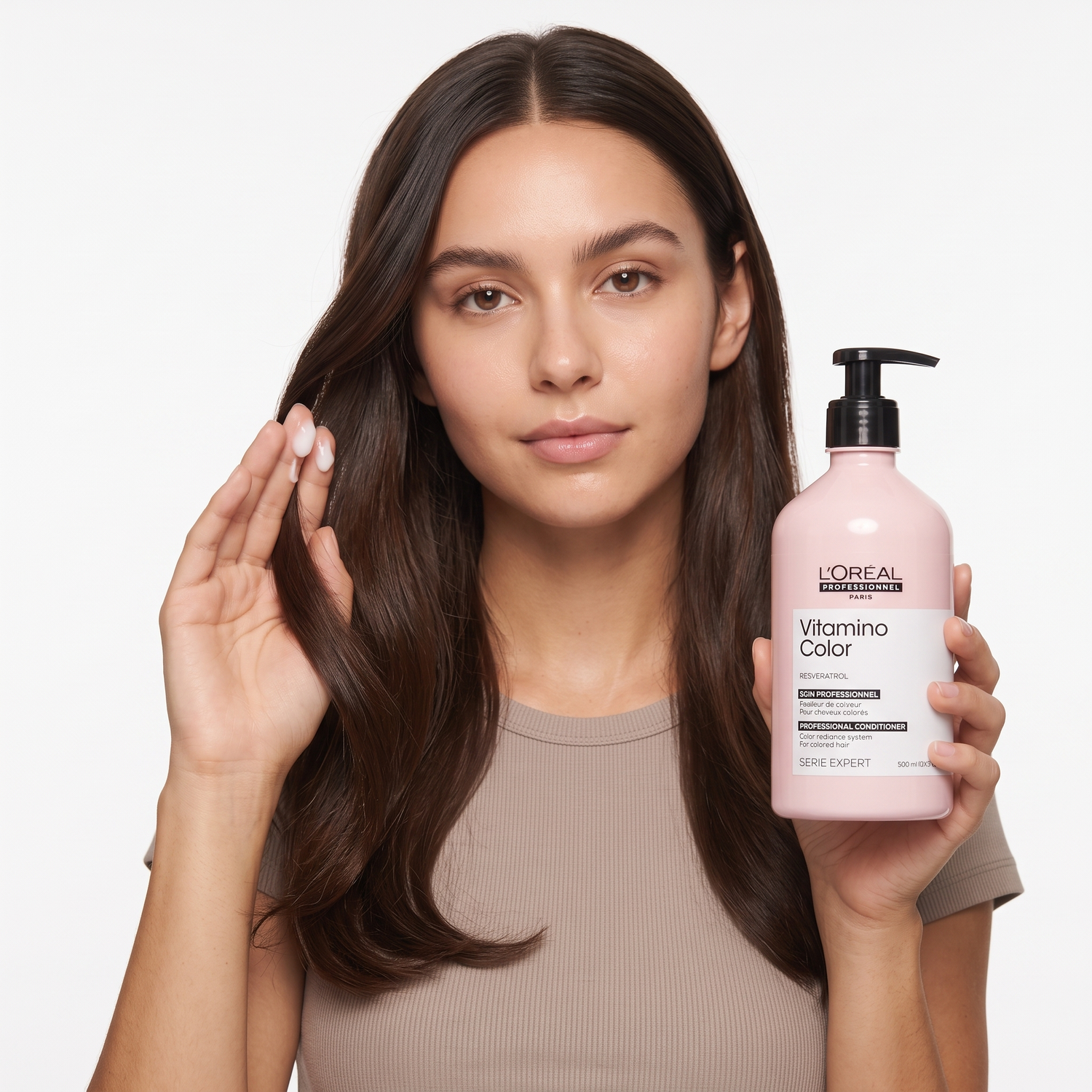 Who should try L'Oréal Vitamino Color Conditioner — model with glossy color-treated hair holding the bottle