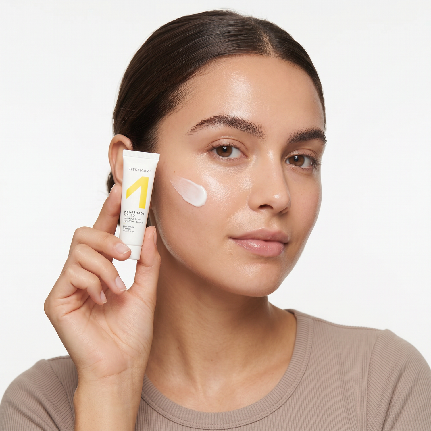 Who should try ZitSticka Megashade Sunscreen Serum SPF 50 — model applying the white sunscreen serum holding the mini tube