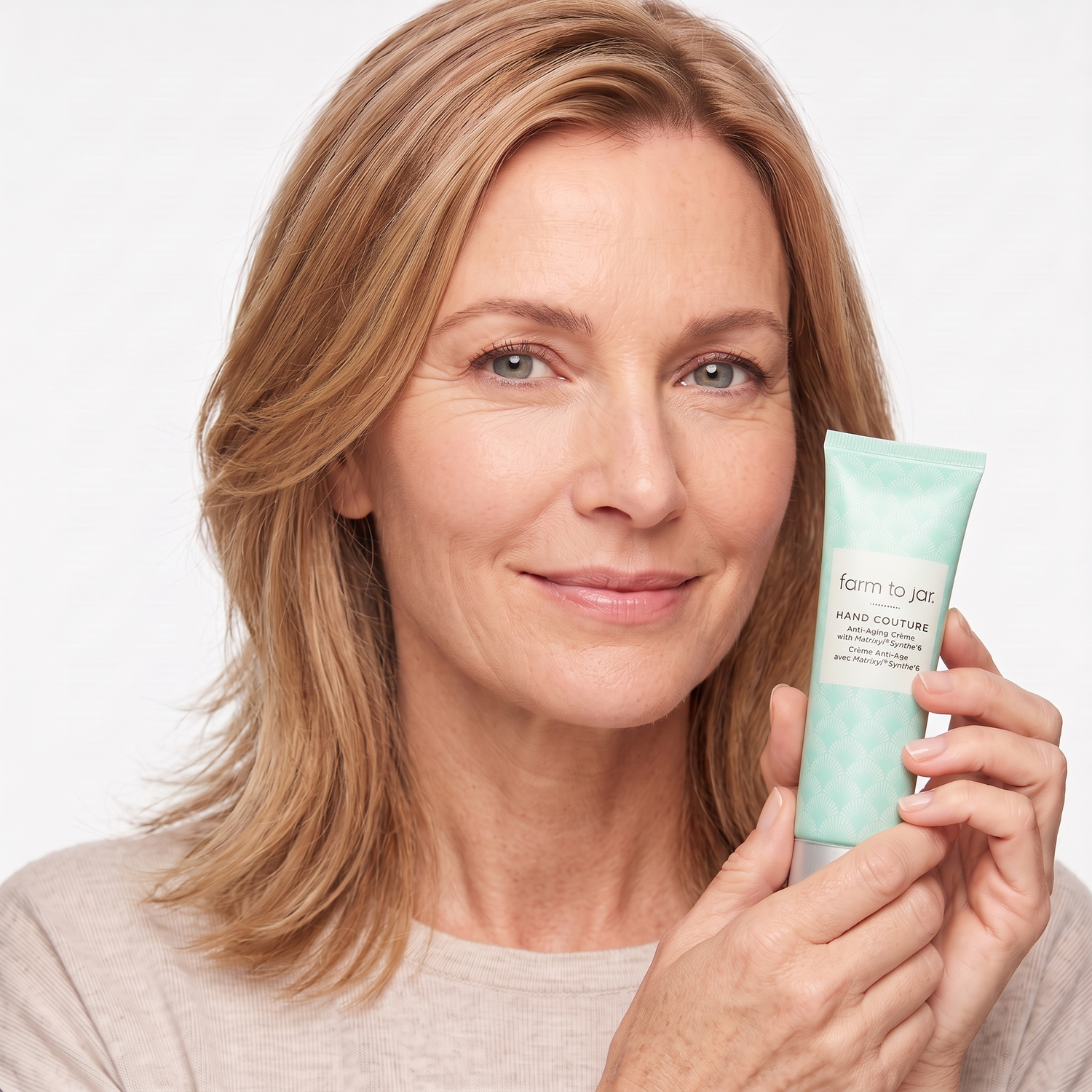 Who should try Aloette Anti-Aging Hand Cream — mature model holding the product