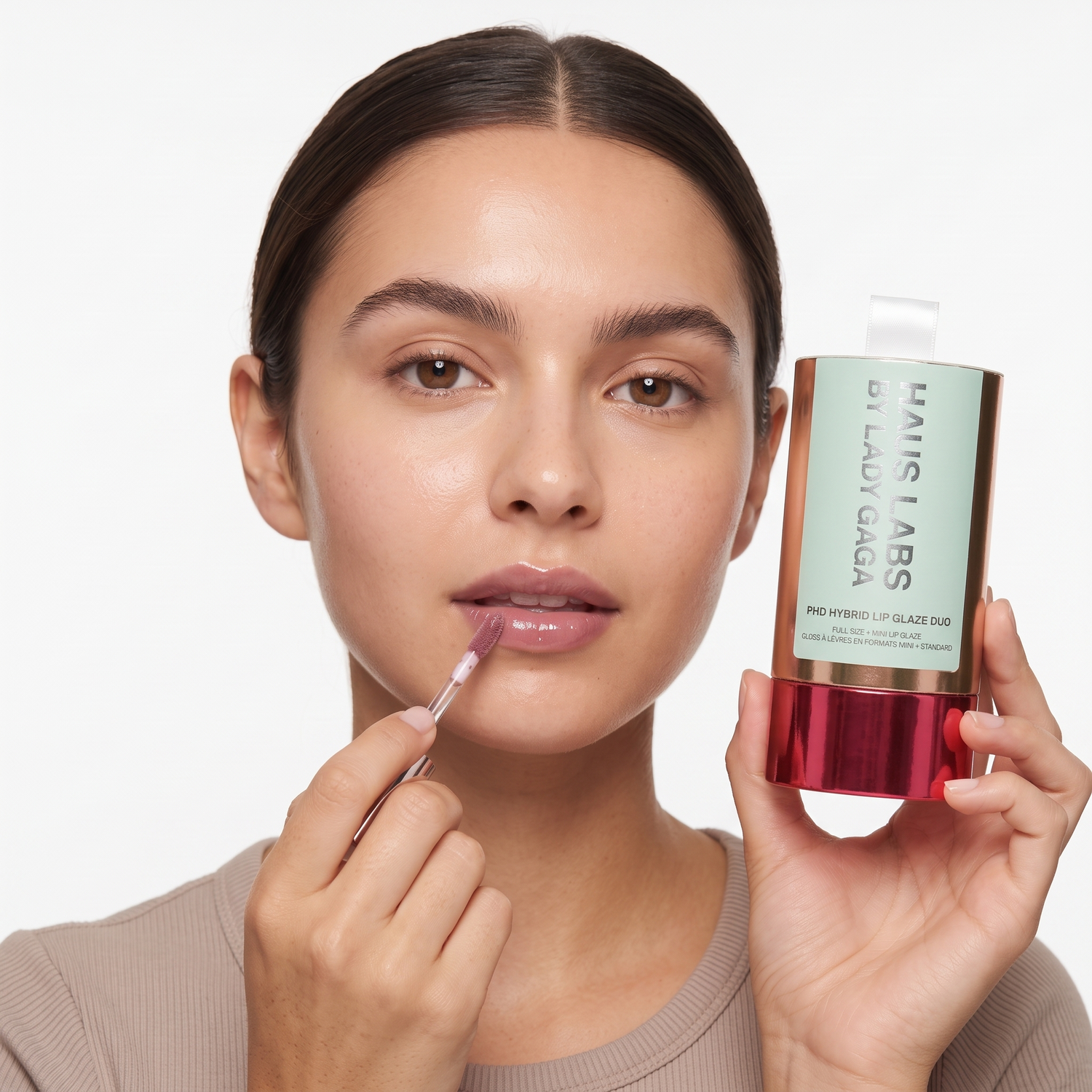 Who should try Haus Labs PHD Hybrid Lip Glaze Duo — model applying gloss and holding the gift box